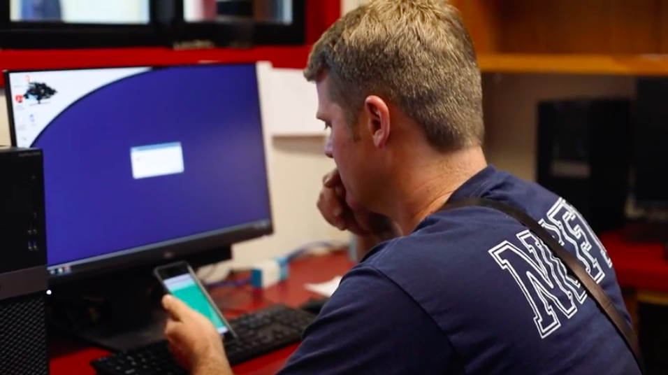 A picture of a firefighter using his phone for a virtual urgent care visit.