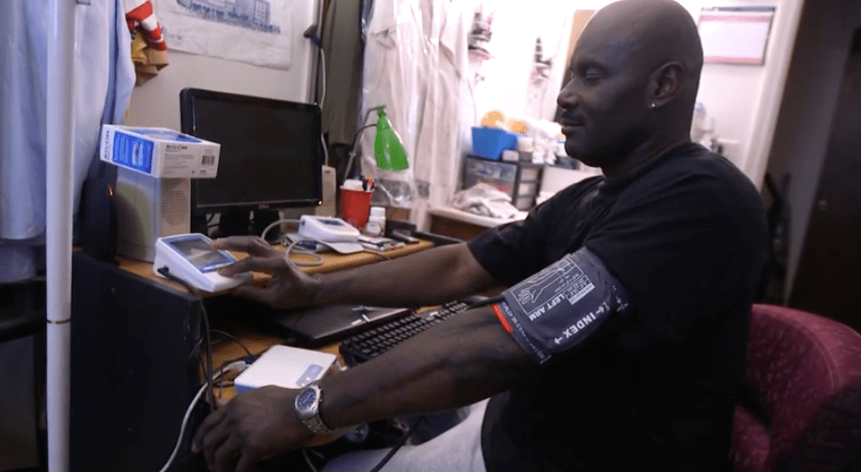 A picture of a man checking his blood pressure.