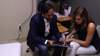 Colleagues discussing information displayed on hand-held device.